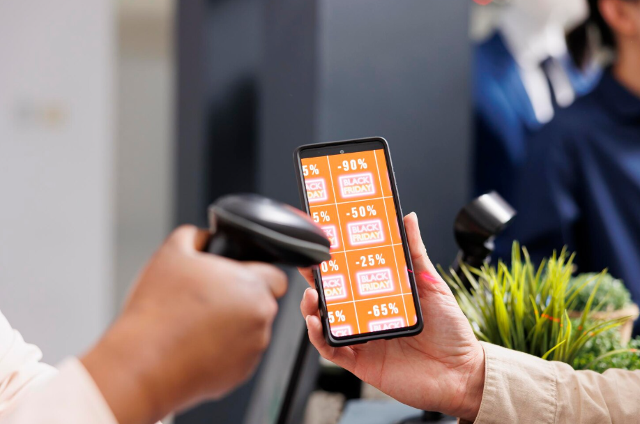 Smartphone displaying Black Friday discounts while being scanned at checkout