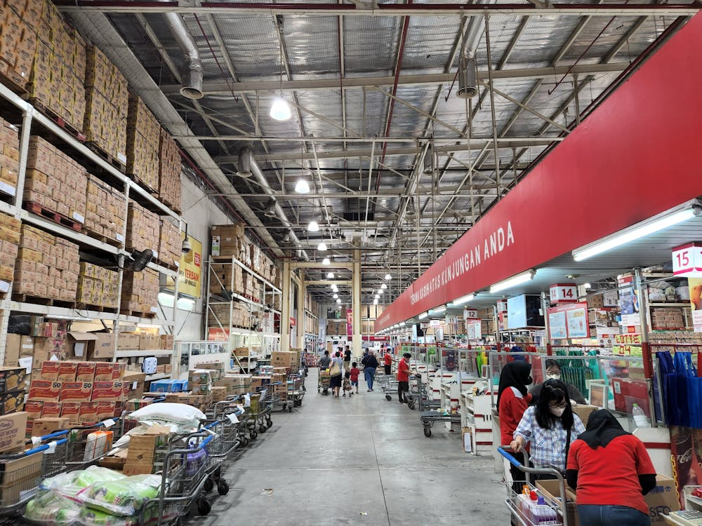 Warehouse club membership shopping with bulk products showing potential savings.