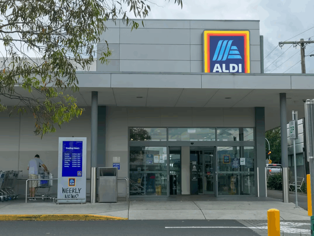 Aldi grocery store entrance in the U.S. with shopping carts and signage.