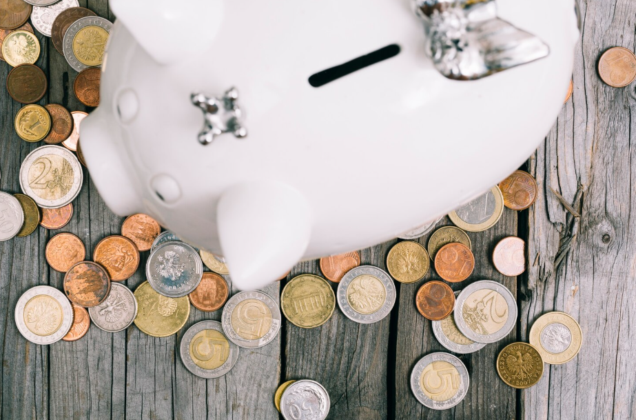 White piggy bank with scattered coins symbolizing easy ways to save money.